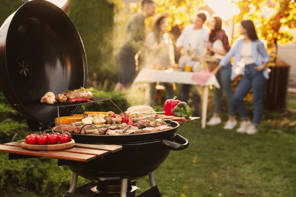 GroupOfFriendsHavingPartyOutdoorsFocusOnBarbecueGrill - Kocher's Water Pumps & Tanks Inc.
